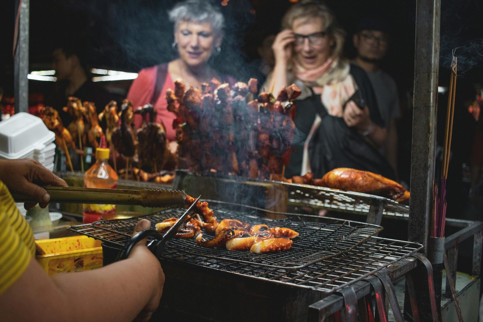 Vibrant street food barbecue scene at Hội An night market, featuring grilled seafood and skewers.