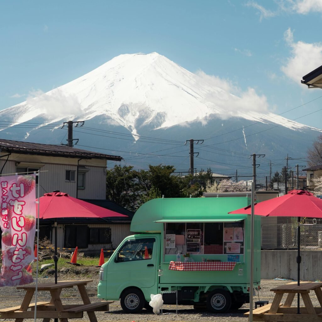 A vibrant food truck set against the iconic snow-capped Mount Fuji in Japan, capturing a blend of culture and scenic beauty.