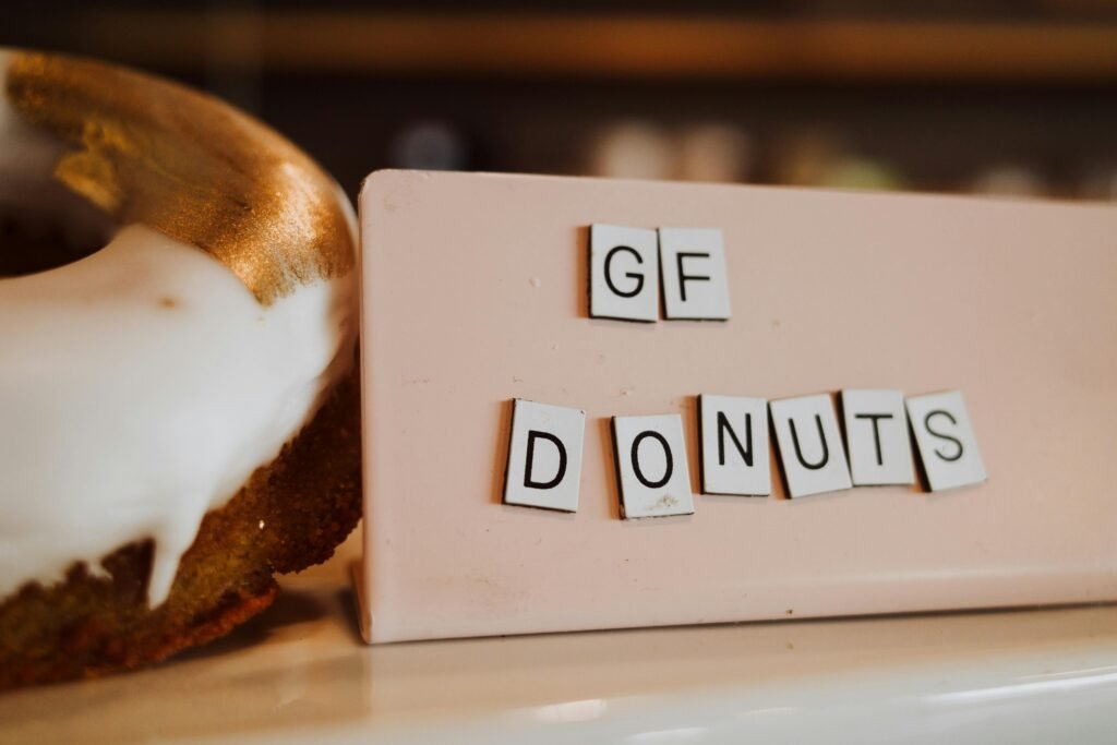 Delicious gluten-free donuts with white icing and gold accents on a pastel background.